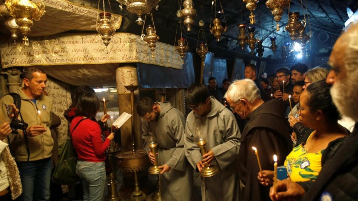 Christian worshippers and clerics pray inside the Grotto, believed to be the exact spot where Jesus Christ was born, at the Church of the Nativity in the biblical West Bank city of Bethlehem, on December 22, 2018, three days ahead of the Christmas celebration. Musa Al Shaer/AFP