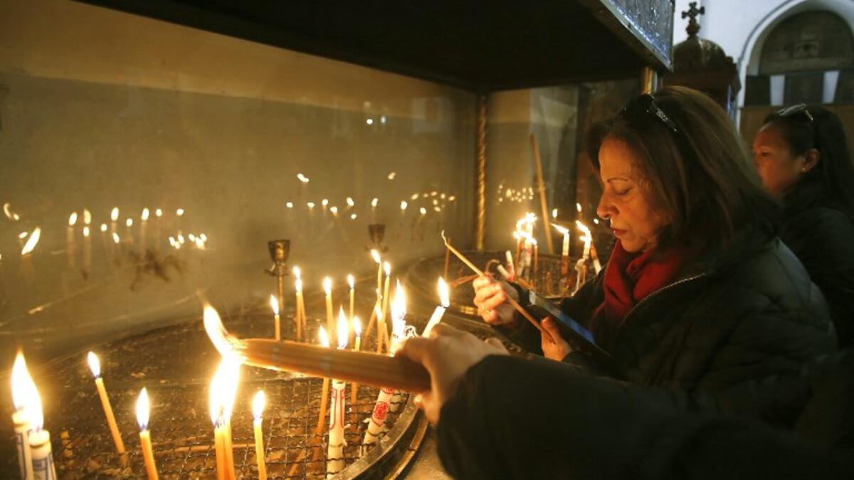 Christian worshipers light candles at the Church of the Nativity in the biblical West Bank city of Bethlehem, on December 22, 2018, three days ahead of the Christmas celebration. Musa Al Shaer/AFP