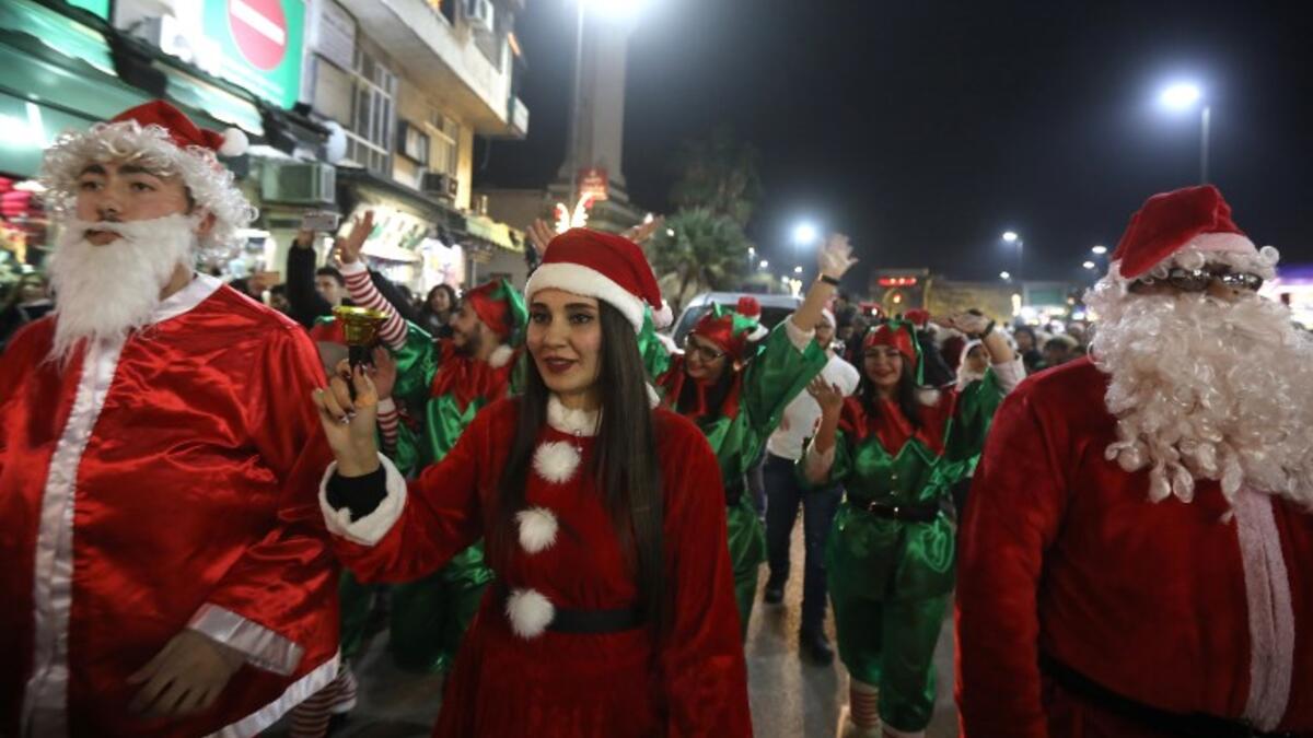 Syrian people dressed as Santa Claus walk in the capital Damascus' central neighbourhood of Qassaa to celebrate Christmas early on December 22, 2018. 
LOUAI BESHARA / AFP