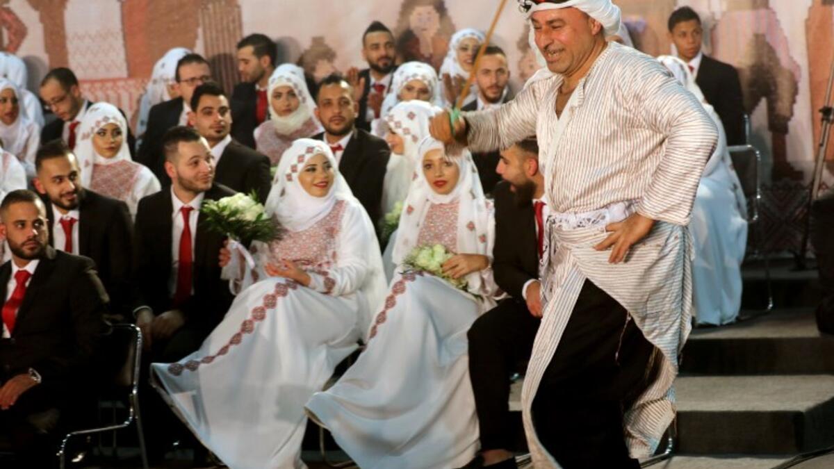 A man dressed in traditional Palestinian clothing dances during a mass wedding ceremony in the Lebanese fishing town of Rmaile, south of the capital Beirut
Mahmoud ZAYYAT / AFP