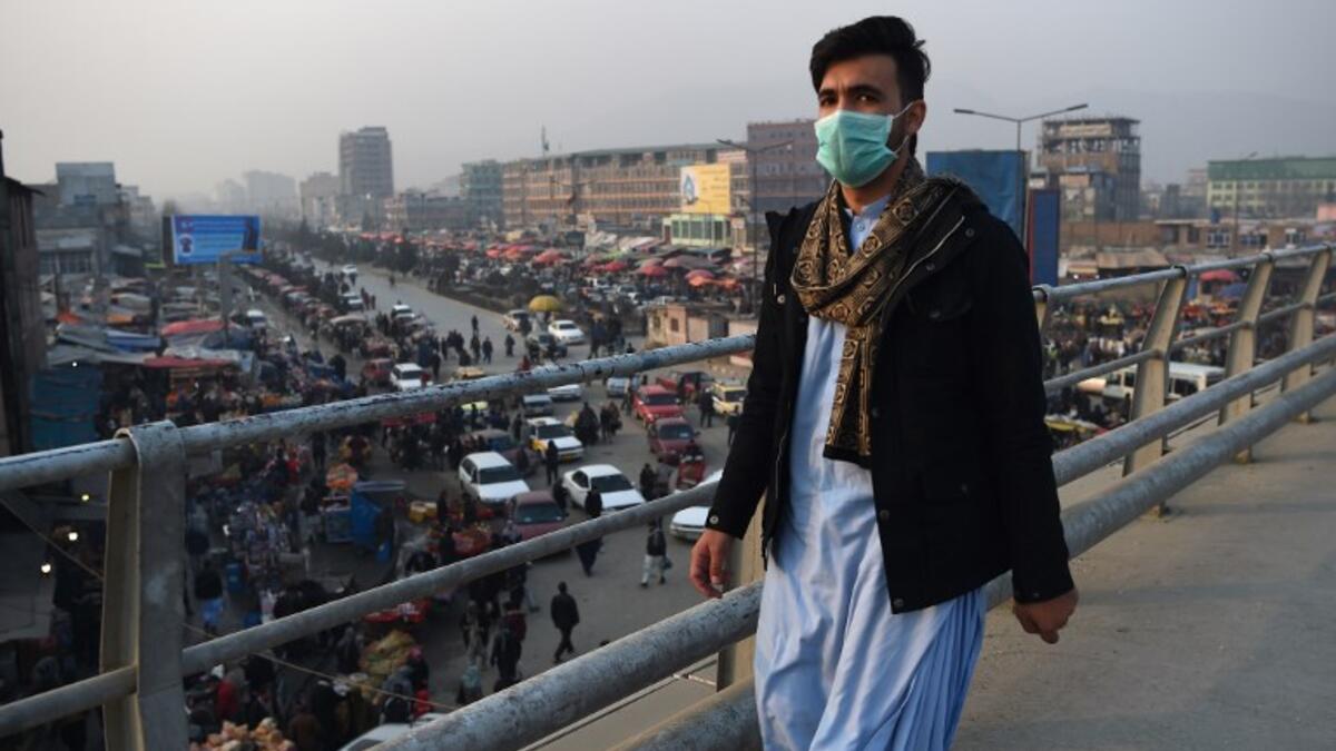 In this photograph an Afghan resident wearing a face mask walks along an overpass amid heavy smog conditions in Afghanistan's capital Kabul. 
WAKIL KOHSAR / AFP