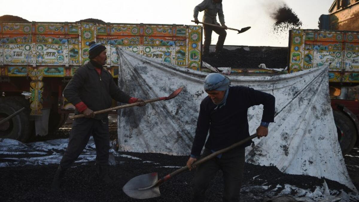 In this picture taken on January 8, 2019, Afghan labourers work at a coal yard amid heavy smog conditions in the outskirts of Kabul. 
WAKIL KOHSAR / AFP