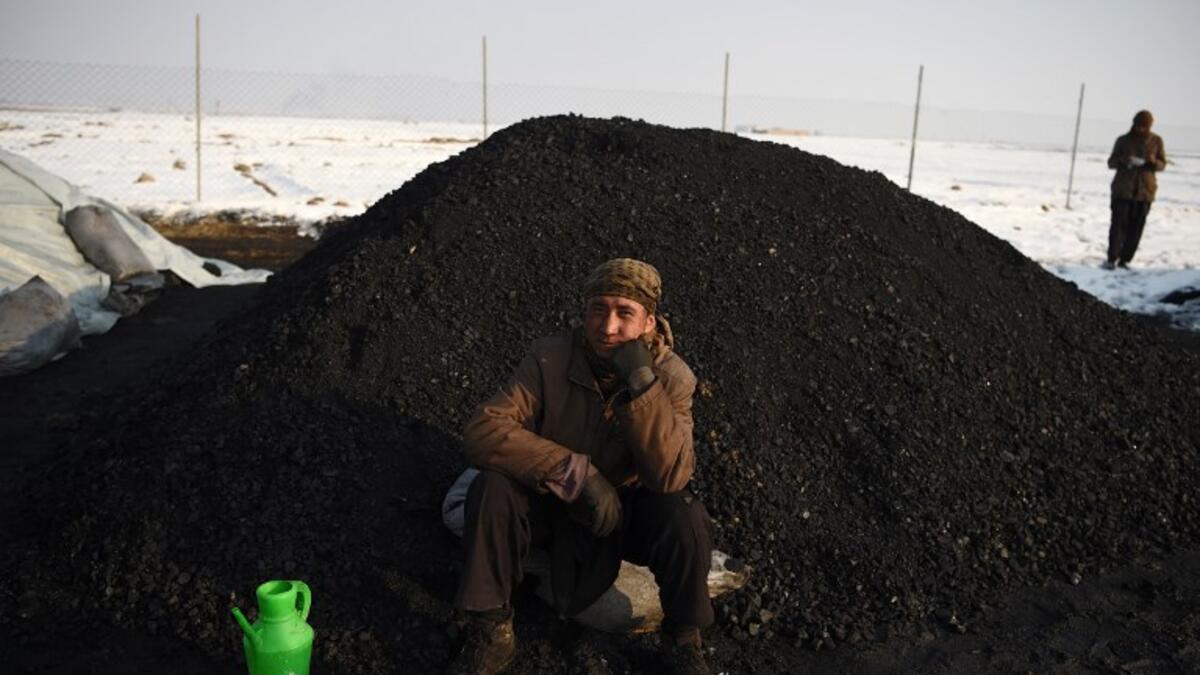 In this picture, an Afghan day labourer sits next to a pile of coal at a coal yard amid heavy smog conditions in the outskirts of Kabul. 
WAKIL KOHSAR / AFP