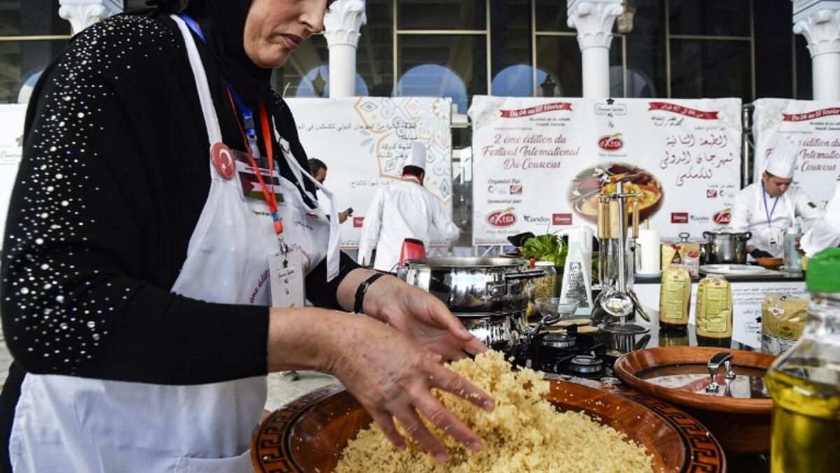 A woman prepares couscous during the 2nd edition of the International Couscous Festival at the Moufdi Zakaria Palace of Culture in Algeria
RYAD KRAMDI / AFP