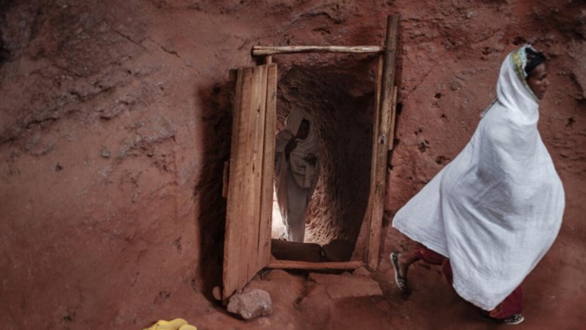 Ethiopian Orthodox devotees enter inside a tunnel leading to the rock-hewn church of Saint Emmanuel, in Lalibela, Ethiopia 
EDUARDO SOTERAS / AFP