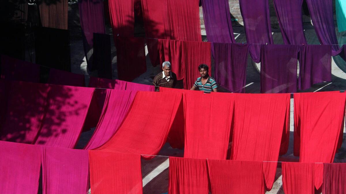 A Pakistani worker dries fabric threads after dyeing them at a factory in Lahore (Twitter)