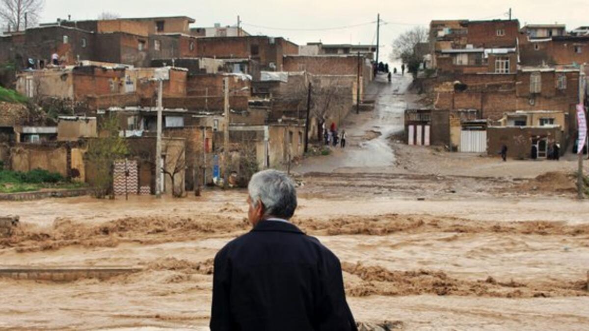 An Iranian man looking at the flooded street in a village around the city of Ahvaz, in Iran's Khuzestan province (Twitter)