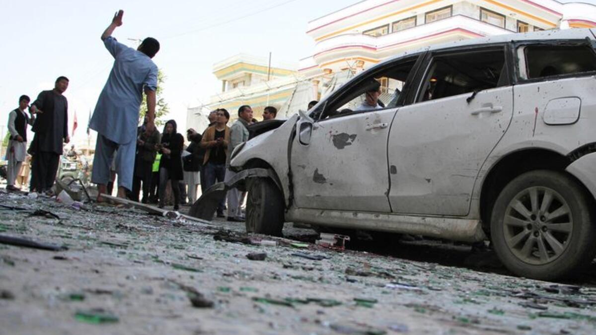 Afghan police officers inspect the scene of the suicide bomb attack that struck a voters registration centre on Sunday. (AFP Photo)
