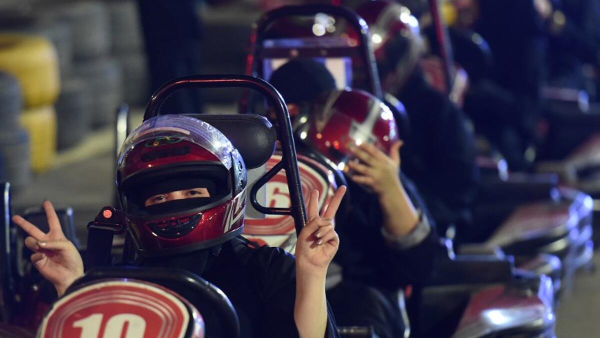 A Saudi woman flashes v-sign as she uses a go-cart during a driving workshop for women in the Saudi capital Riyadh on June 21, 2018.
FAYEZ NURELDINE / AFP