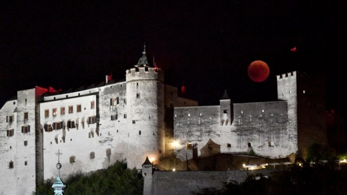 This picture shows the full moon during a 'blood moon' eclipse over the Festung Hohensalzburg castle in Salzburg on July 27, 2018. (AFP/APA/ BARBARA GINDL)