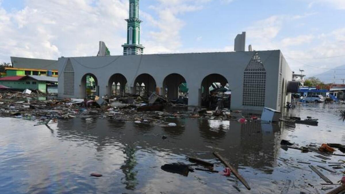 The standing remains of a mosque is seen amid waters from a tsunami surge in Palu, Indonesia's Central Sulawesi on September 30, 2018, following the September 28 earthquake and tsunami. (ADEK BERRY / AFP)