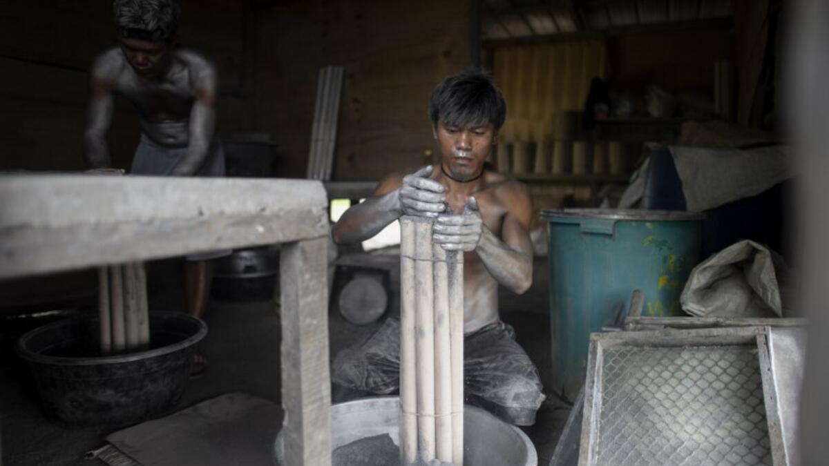 Workers covered with gunpowder material make fireworks for New Year celebrations in Bocaue, Bulacan, north of Manila on December 26, 2018. 
Noel CELIS / AFP