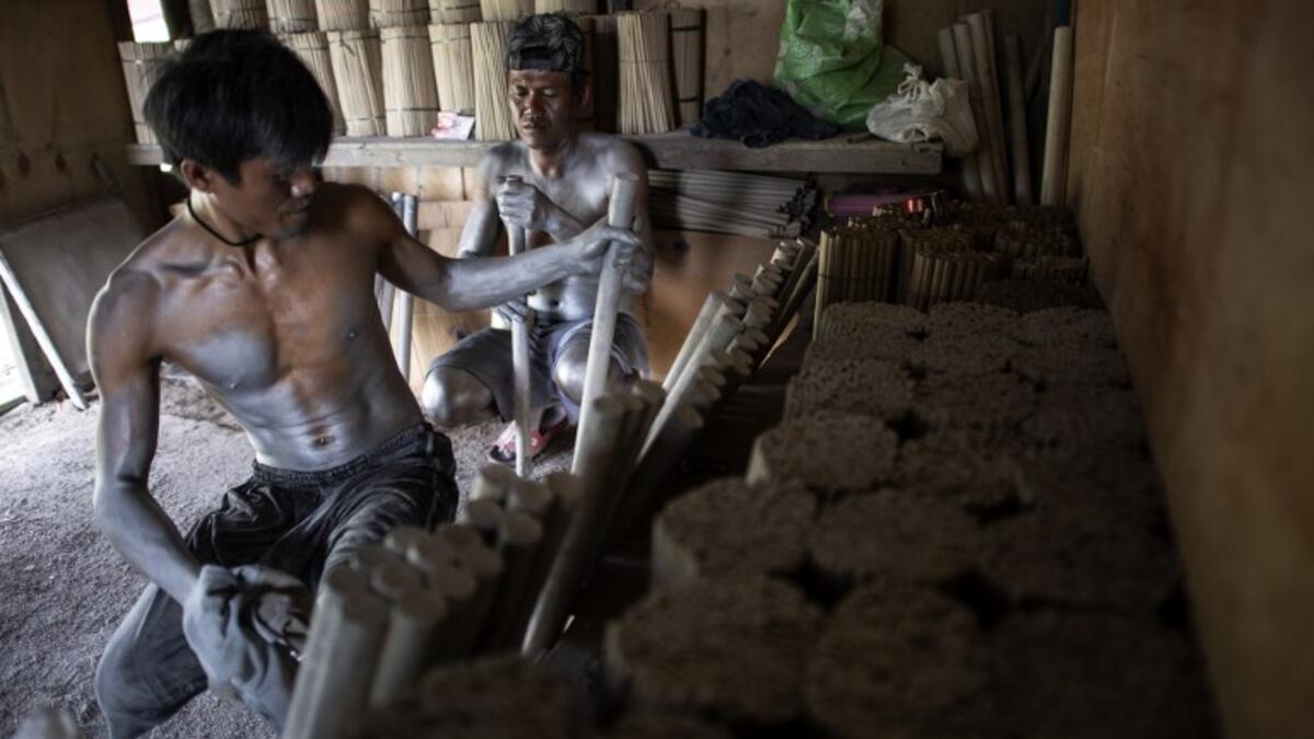 Workers covered with gunpowder material make fireworks for New Year celebrations in Bocaue, Bulacan, north of Manila on December 26, 2018. 
Noel CELIS / AFP