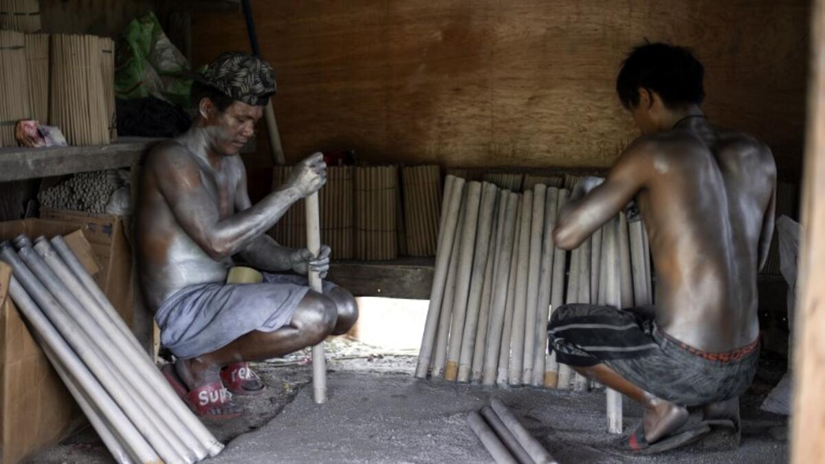 Workers covered with gunpowder material make fireworks for New Year celebrations in Bocaue, Bulacan, north of Manila on December 26, 2018. 
Noel CELIS / AFP