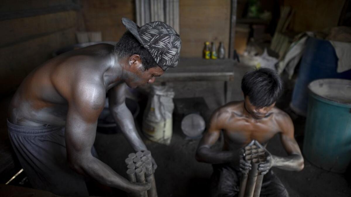 Workers covered with gunpowder material make fireworks for New Year celebrations in Bocaue, Bulacan, north of Manila on December 26, 2018. 
Noel CELIS / AFP