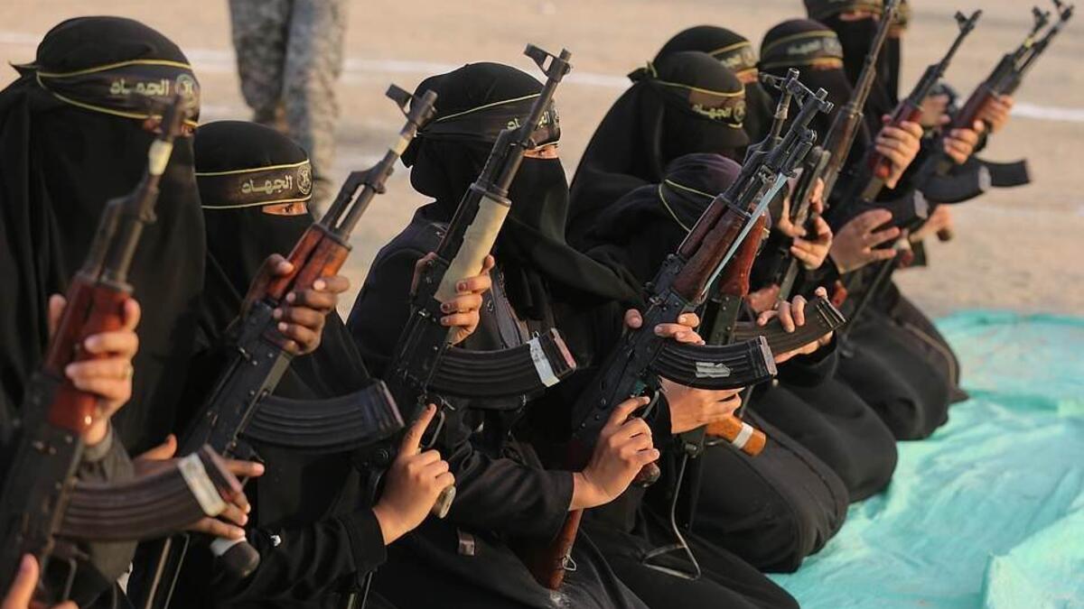 The women of the al-Quds Brigades holding Kalashnikov rifles and poised for action during the exercise at Khan Yunis on the southern section of the Gaza Strip (APA/Shutterstock)
