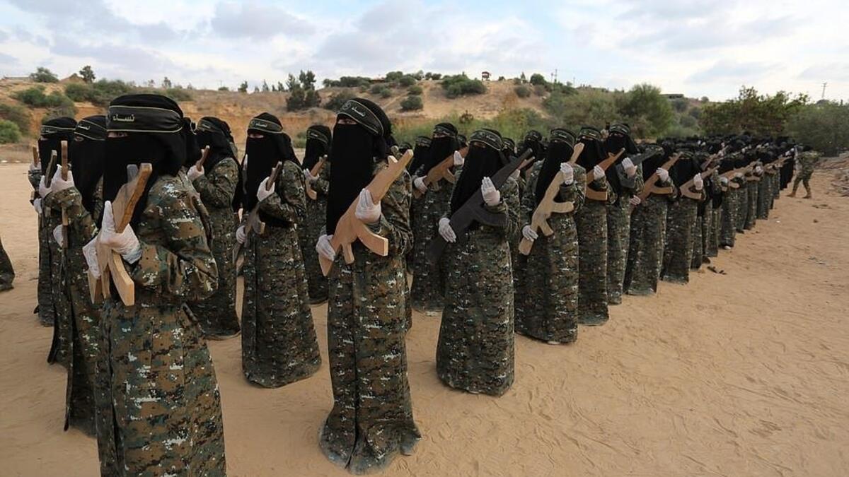 The camouflage wearing women of the outfit stand in line holding wooden rifles.  al-Quds Brigades is the military wing of Islamic Jihad, the second-most powerful armed group in the Gaza Strip after Hamas (APA)
