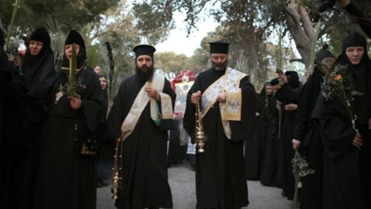 Jerusalem: Christian Orthodox priests and nuns carry palm tree branches during the Palm Sunday procession from Mt. Olives to Jerusalem's Old City.