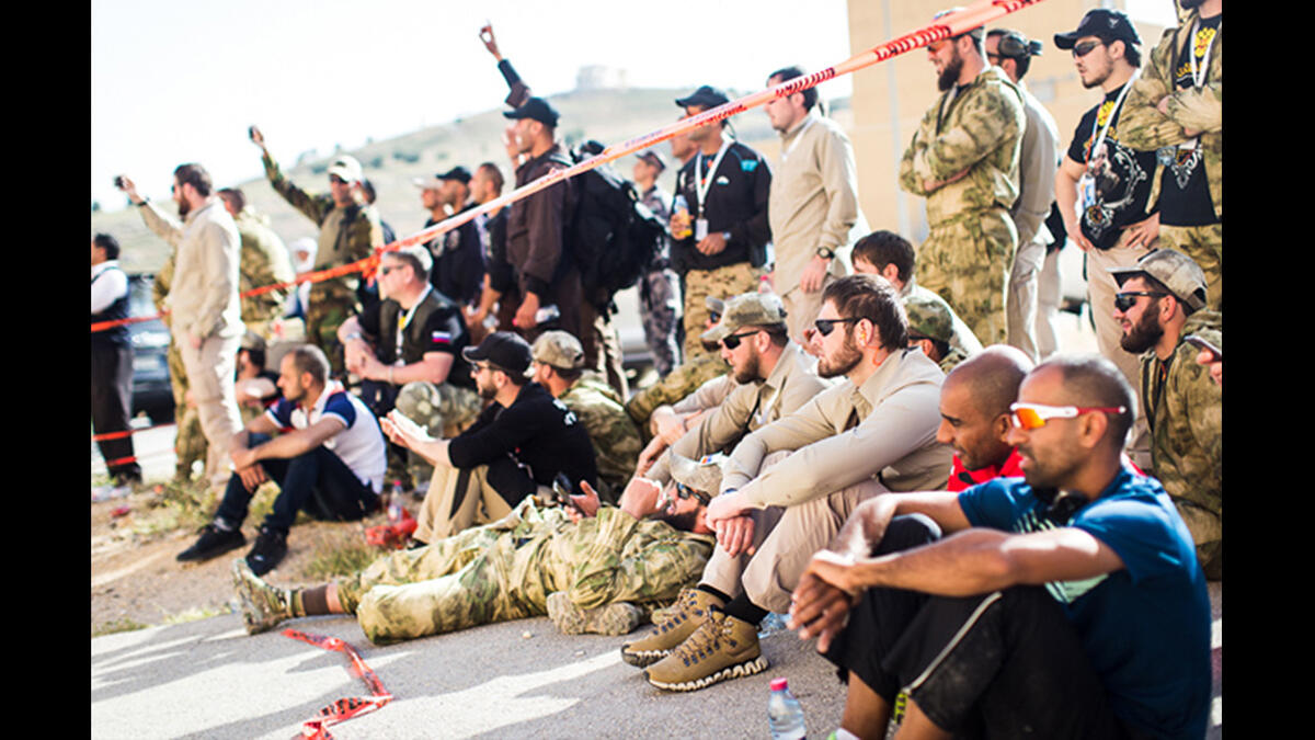 Teams from various countries relax together and cheer on their teammates during the first event of the Warrior Competition, "Top Gun." Here, it’s normal to see soldiers from Chechnya, Afghanistan, Brunei, and Canada chatting together.