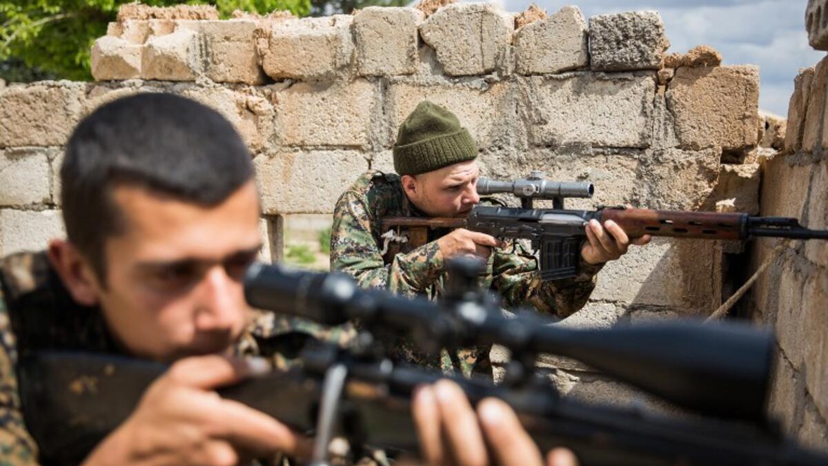 ‘Hewal Dilsad,’ A 26-year old foreign fighter from the US, nick-named by Kurdish fighters, points his sniper gun during clashes with Islamic State (IS) group fighters outside Tal Tamr on April 4, 2015.