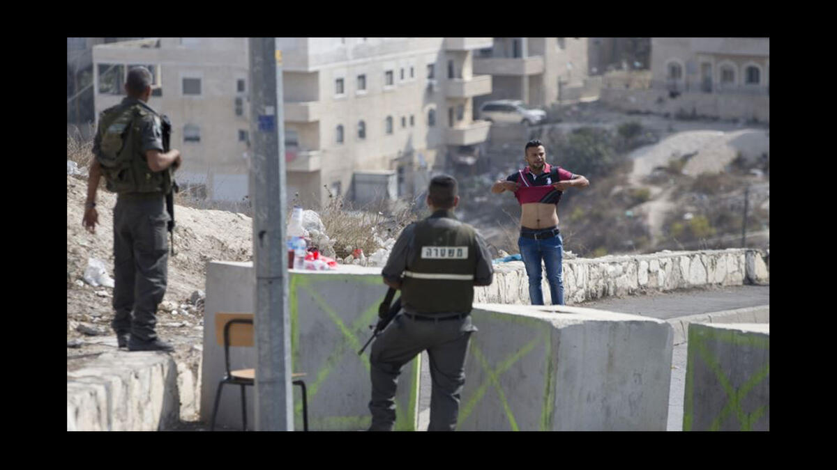 israeli checkpoint with palestinian man