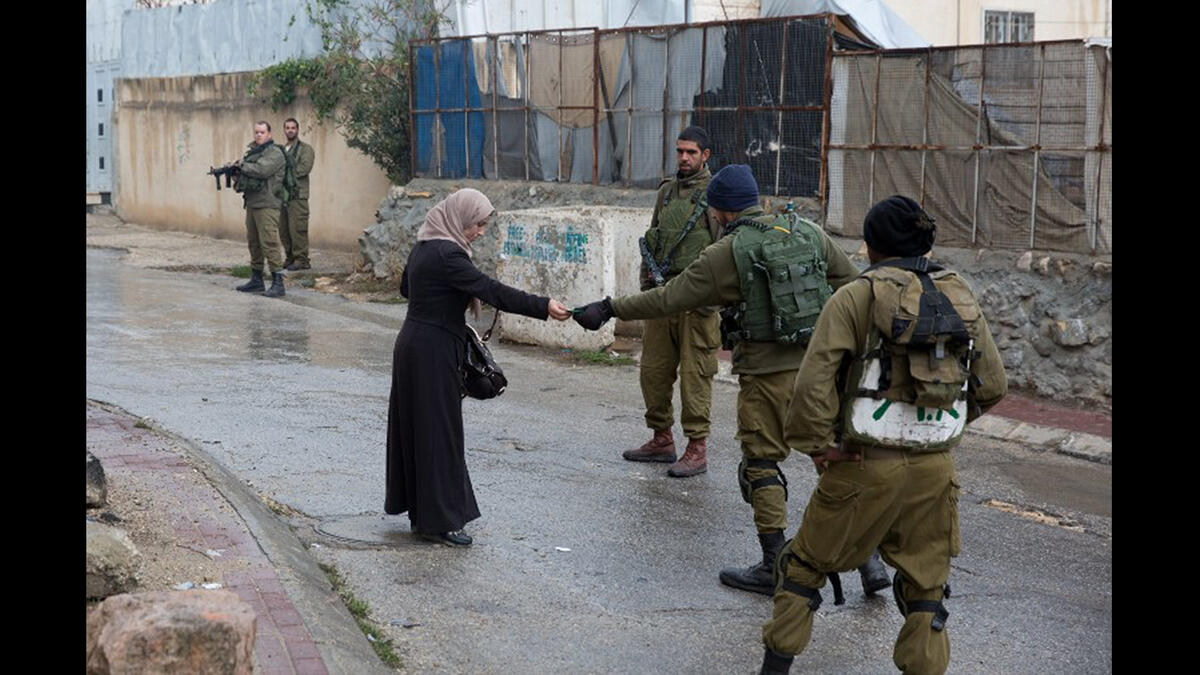 israeli soldiers check woman's ID