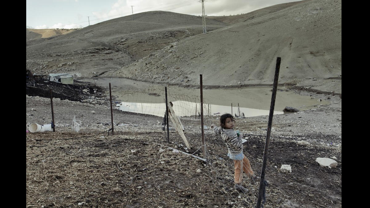 tiny Palestinian girl at the security fence