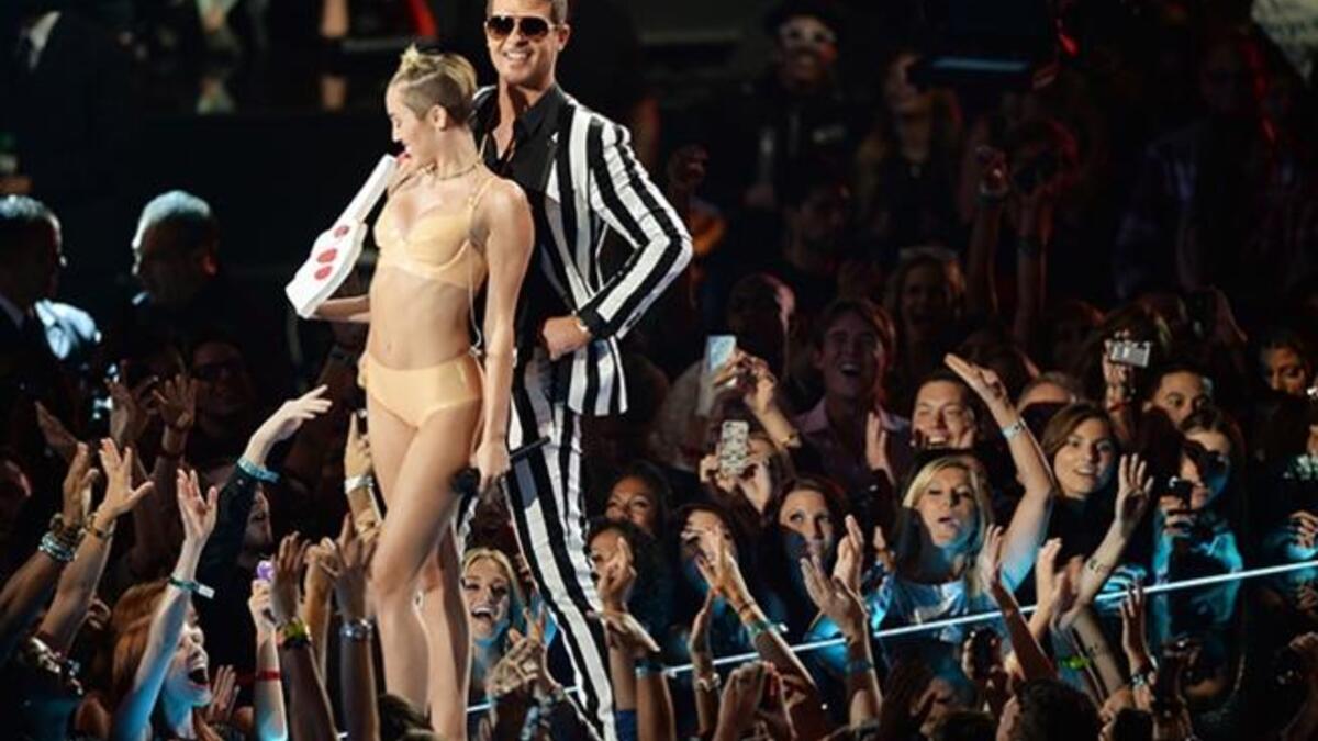 ثم تراقصت سايرس مع ثيكي أثناء أدائهما لأغنية " Blurred Lines" بحركات تشبه إلى حد بعيد حركات راقصات التعري، بالإضافة إلى حركات لسانها المليئة بالإيحاءات الجنسية