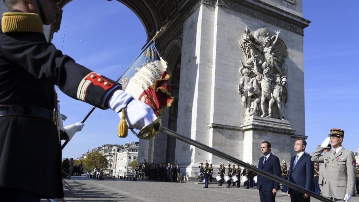 South Korea's President Moon Jae-in (C), flanked by French Junior Minister attached to the Minister of Ecological and Inclusive Transition Sebastien Lecornu (L), and Military Governor of Paris Lieutenant-General Bruno Le Ray (R). (ALAIN JOCARD / AFP)
