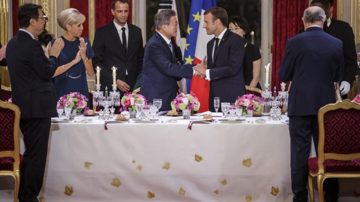 French President Emmanuel Macron (C-R), his wife Brigitte Macron (L), South Korean President Moon Jae-in (C-L) and his wife Kim Jung-sook (R) toast during a state dinner at the Elysee Presidential palace in Paris, on October 15, 2018. (Christophe Petit-Tesson / POOL / AFP)
