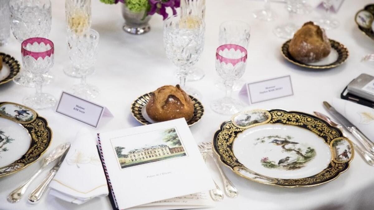 Menu, porcelain plates, glasses and tableware are pictured during the state dinner hosted by the French President for the South Korean President at the Elysee Palace in Paris, France, on October 15, 2018. 
(Christophe Petit-Tesson / POOL / AFP)
