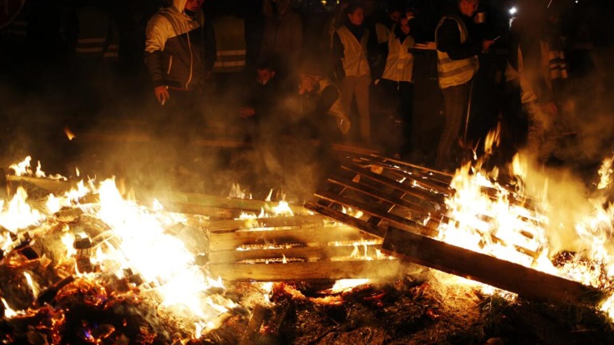 People block the Caen's circular road on November 18, 2018 in Caen, northwestern France, on a second day of action after a nationwide popular initiated day of protest called "yellow vest"  against fuel prices.
CHARLY TRIBALLEAU / AFP