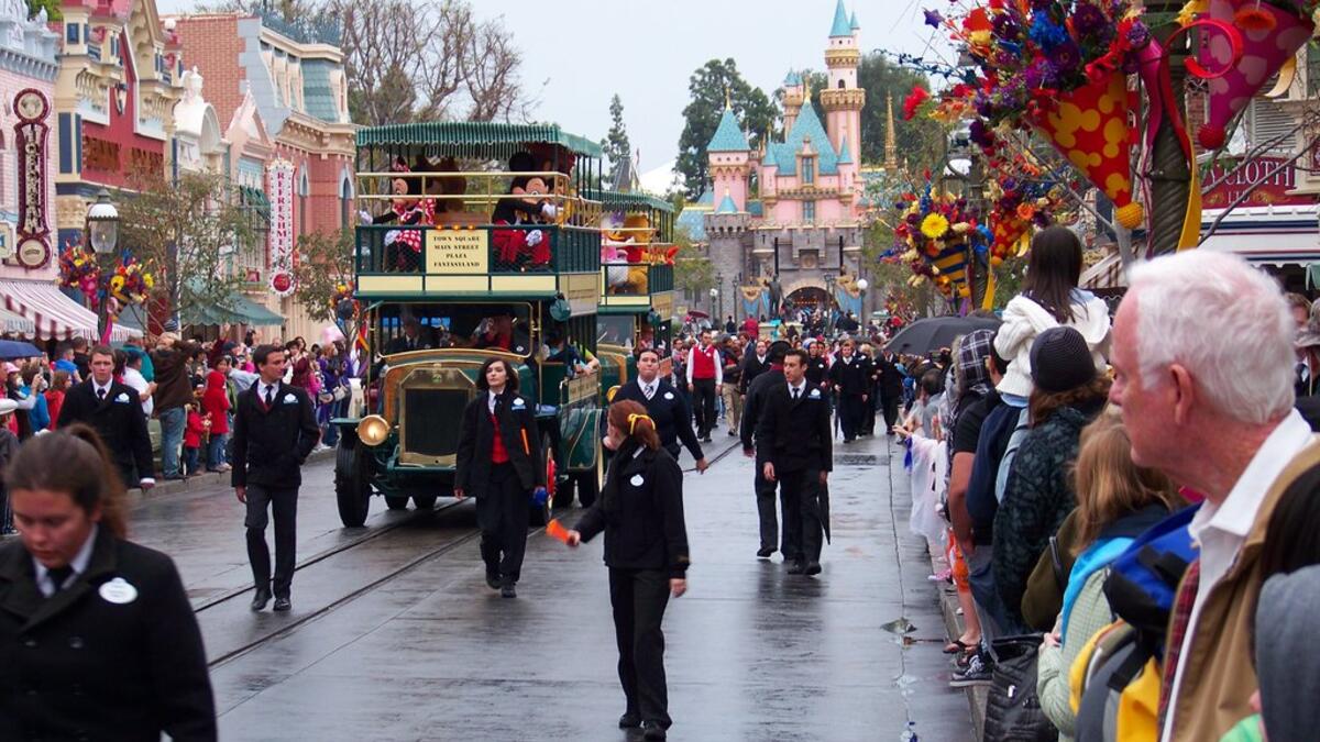 People gather to watch Disneyland characters in fairy vehicles. (popsugar.com)