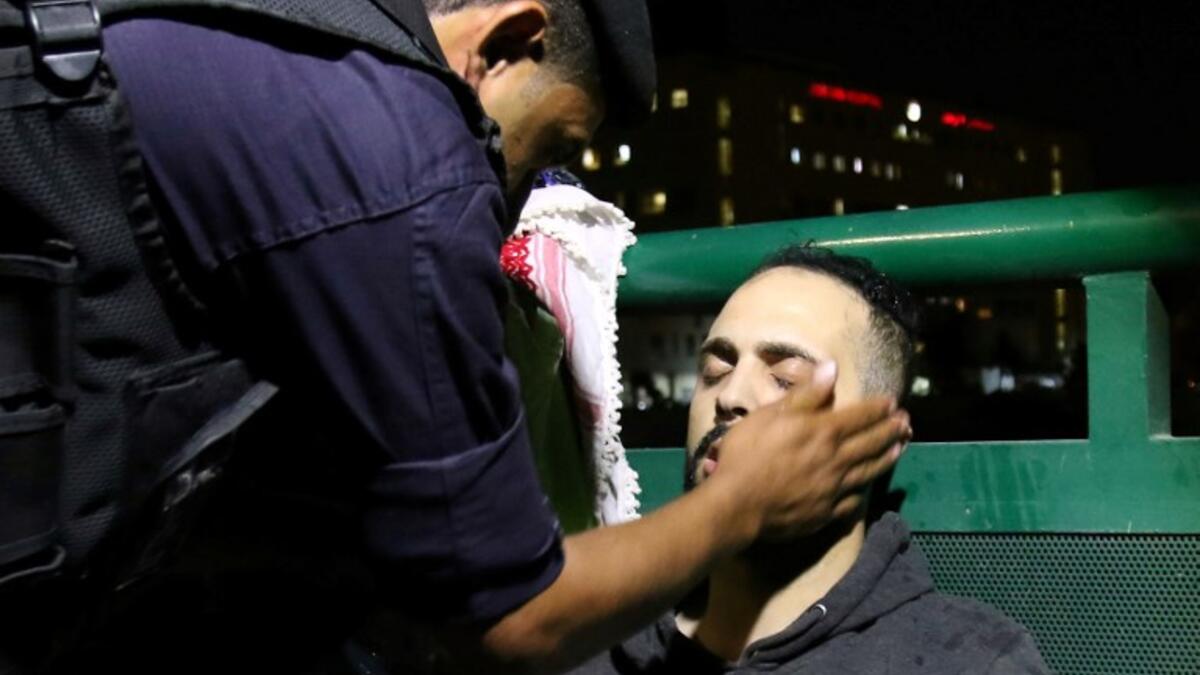 Jordanian riot police attend to a protester who passed out during a demonstration outside the prime minister's office in the capital Amman late on June 3, 2018. 
Khalil MAZRAAWI / AFP