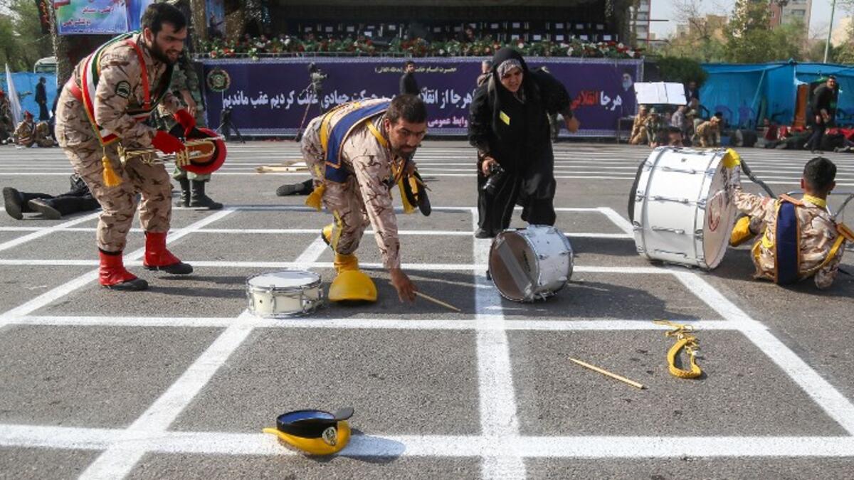 September 22, 2018 in the southwestern Iranian city of Ahvaz shows members of an Iranian military marching band reaching for their fallen instruments at the scene of an attack on a military parade that was marking the anniversary of the outbreak of its devastating 1980-1988 war with Iraq. (MORTEZA JABERIAN / ISNA / AFP)
