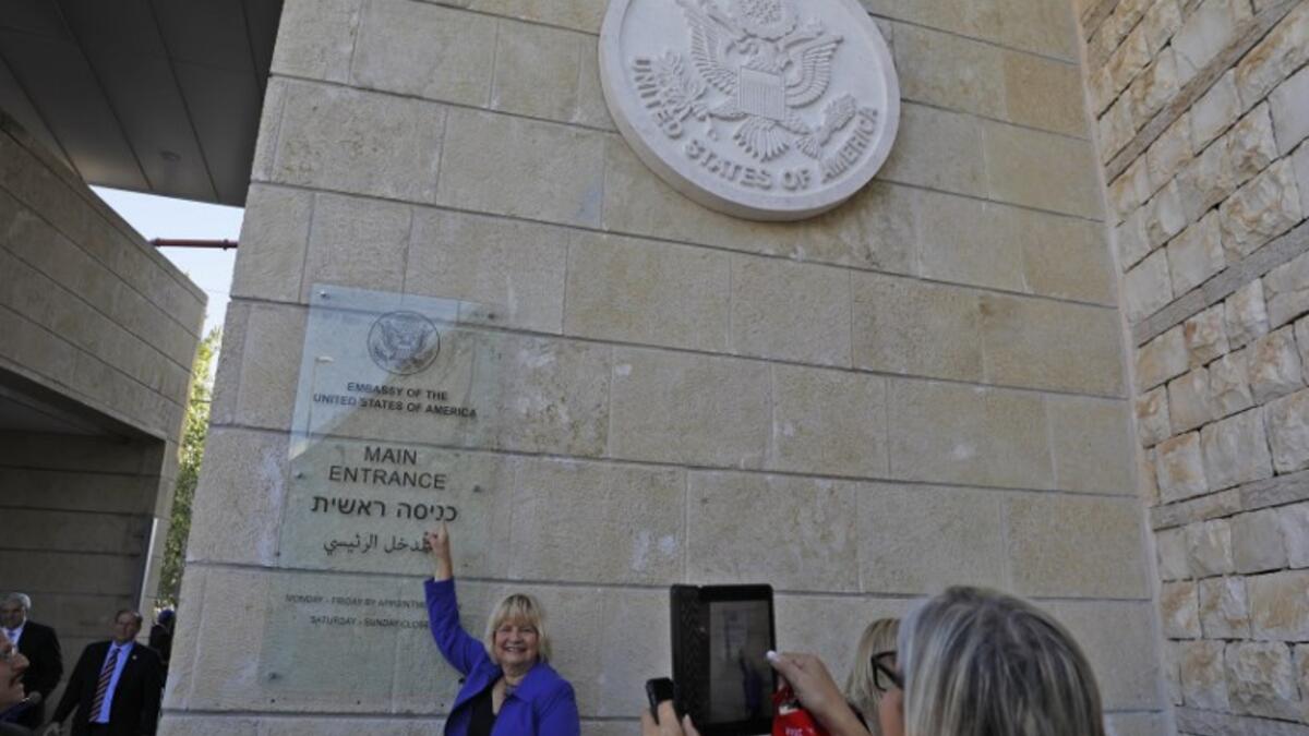 A woman poses for a picture next to an inauguration plaque during the opening of the US embassy in Jerusalem on May 14, 2018. Palestinian anger and exuberant praise from Israelis over President Donald Trump's decision tossing aside decades of precedent.
Menahem KAHANA / AFP