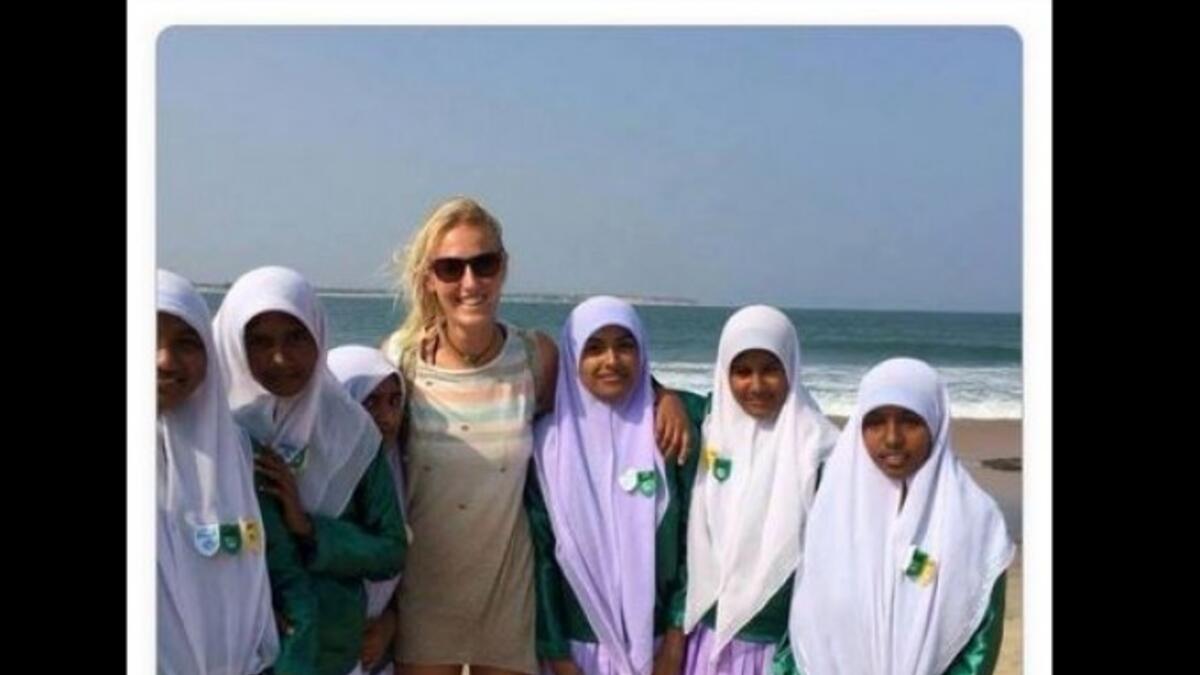 blonde woman in shorts with modestly dressed Muslims