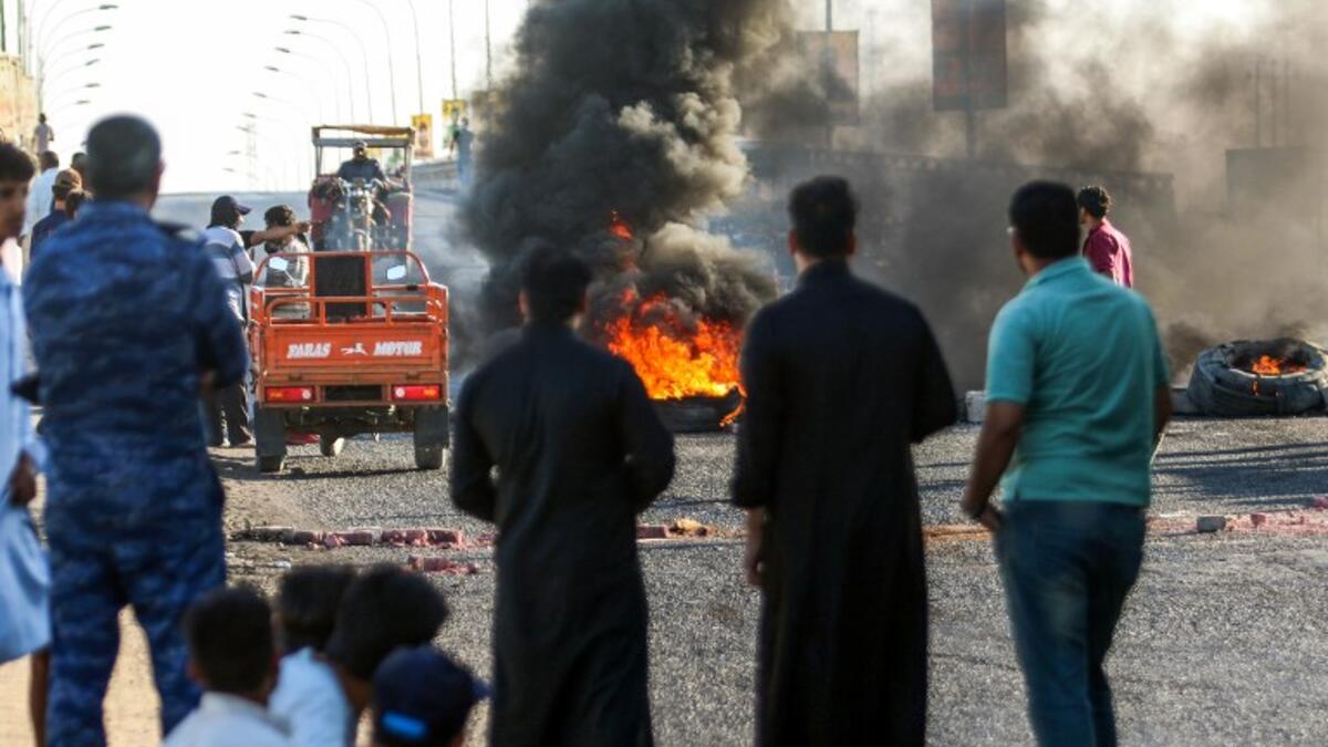 Iraqi protesters, who are demonstrating against corruption and lack of basic services, burn tires as they block the main road between the centre of the southern city of Basraon September 2, 2018. 
Haidar MOHAMMED ALI / AFP
