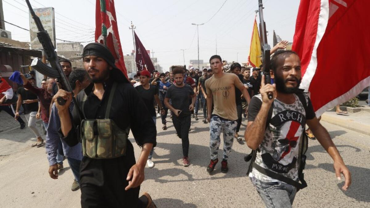 Armed Iraqi civilians attend the funeral of a man on September 4, 2018, that family and Human rights activists claim was killed by bullet shots during the previous day, while demonstrating against the government and the lack of basic services, in the southern city of Basra.
Haidar MOHAMMED ALI / AFP