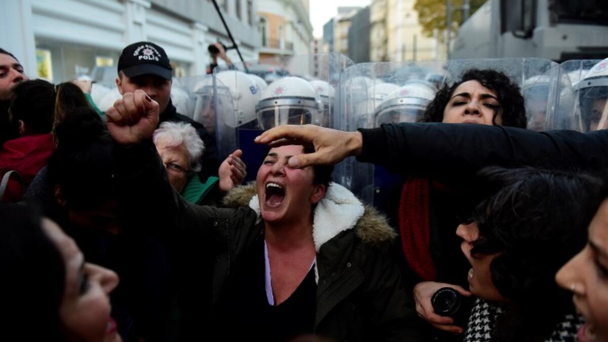 Women's rights activists react during clashes with Turkish riot police as they try to march to Taksim Square to protest against gender violence in Istanbul, on November 25, 2018, on the International Day for the Elimination of Violence against Women. 
Yasin AKGUL / AFP