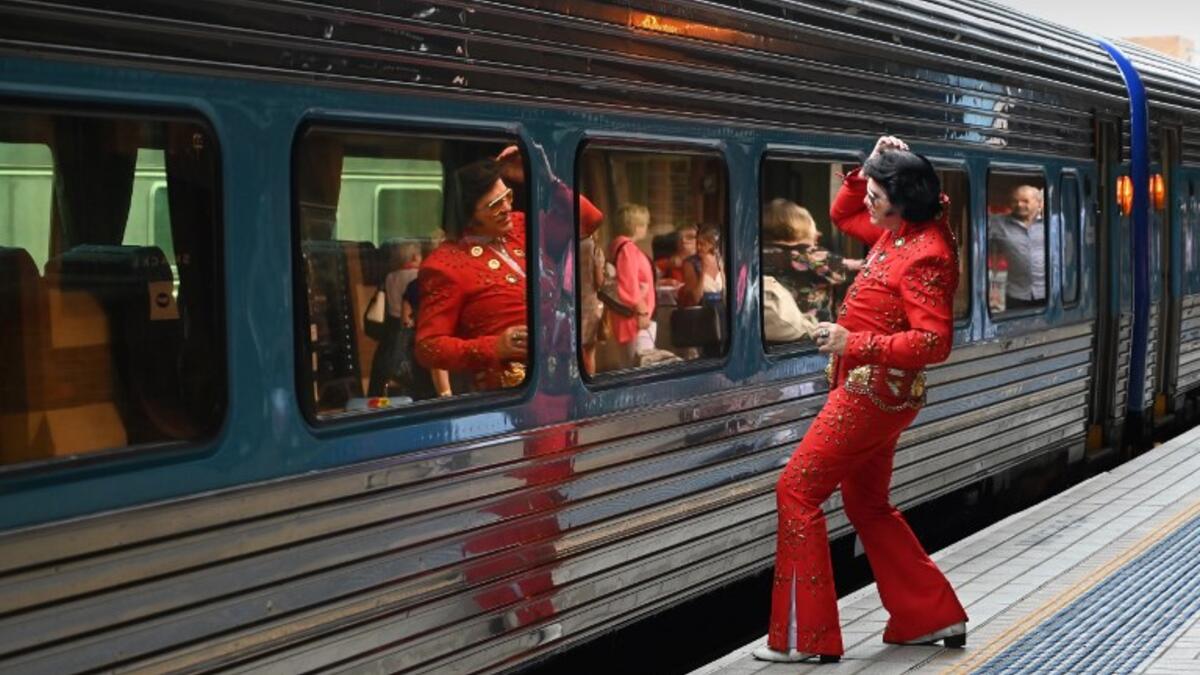 An Elvis fan uses the train window as a mirror at Central station before boarding a train to The Parkes Elvis Festival, in Sydney on January 10, 2019. 
PETER PARKS / AFP