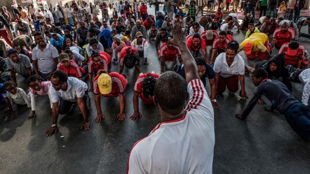 People take part in an exercise on a street in Addis Ababa on February 3, 2019 during the third Car Free Day promoted by local NGOs and the Ethiopian Government to appeal to a healthy life style and a less air pollution of the capital city. 
EDUARDO SOTERAS / AFP