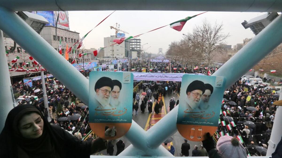 Iranians hold up signs showing portraits of the country's Supreme Leader Ali Khamenei (L) and his predecessor and Islamic Revolution founder Ayatollah Ruhollah Khomeini.
ATTA KENARE / AFP