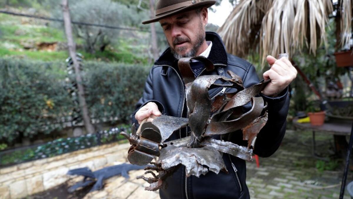Lebanese Artist Charles Nassar inpsects his sculptures made out of artillery shrapnels in the village of Remhala, south of Beirut, on March 7, 2019.
JOSEPH EID / AFP
