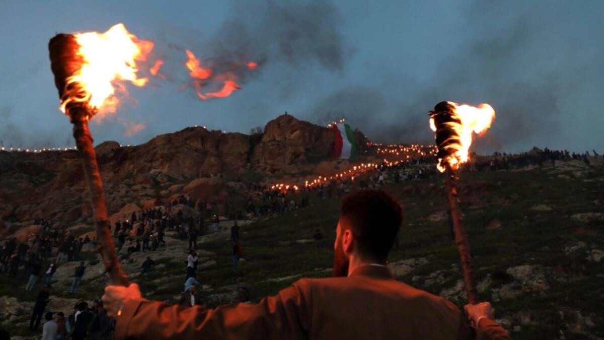 An Iraqi Kurd holds lit torches in the town of Akra, 500 kilometres north of the capital Baghdad, on March 20, 2019, during celebrations of Nowruz (Noruz), the Persian New Year.
SAFIN HAMED / AFP