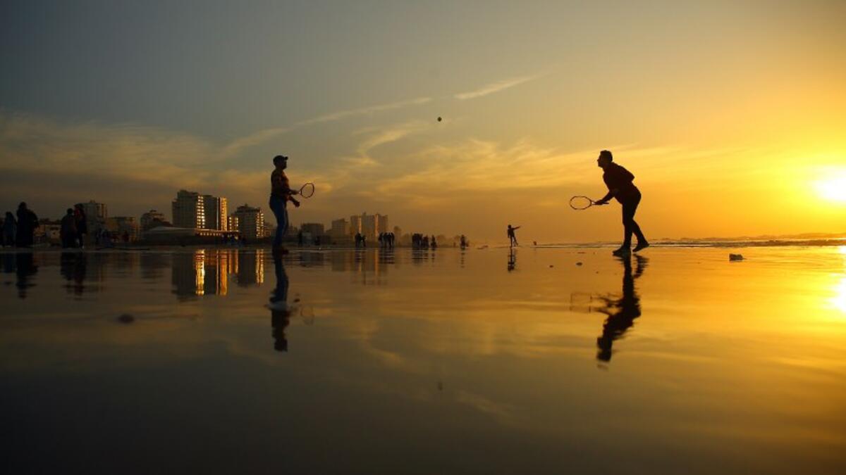 Palestinians play tennis on the beach during the sunset in Gaza City on January 11, 2017. (AFP/MOHAMMED ABED)