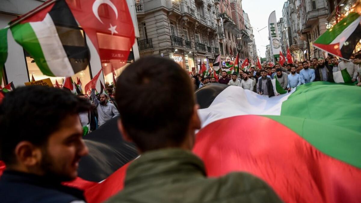 Protesters march as they wave a giant Palestinian flag and also Palestinian flags at the Istikilal avenue in Istanbul on May 14, 2018 during a demonstration against US President's decision to move the US embassy from Tel Aviv to Jerusalem. OZAN KOSE / AFP