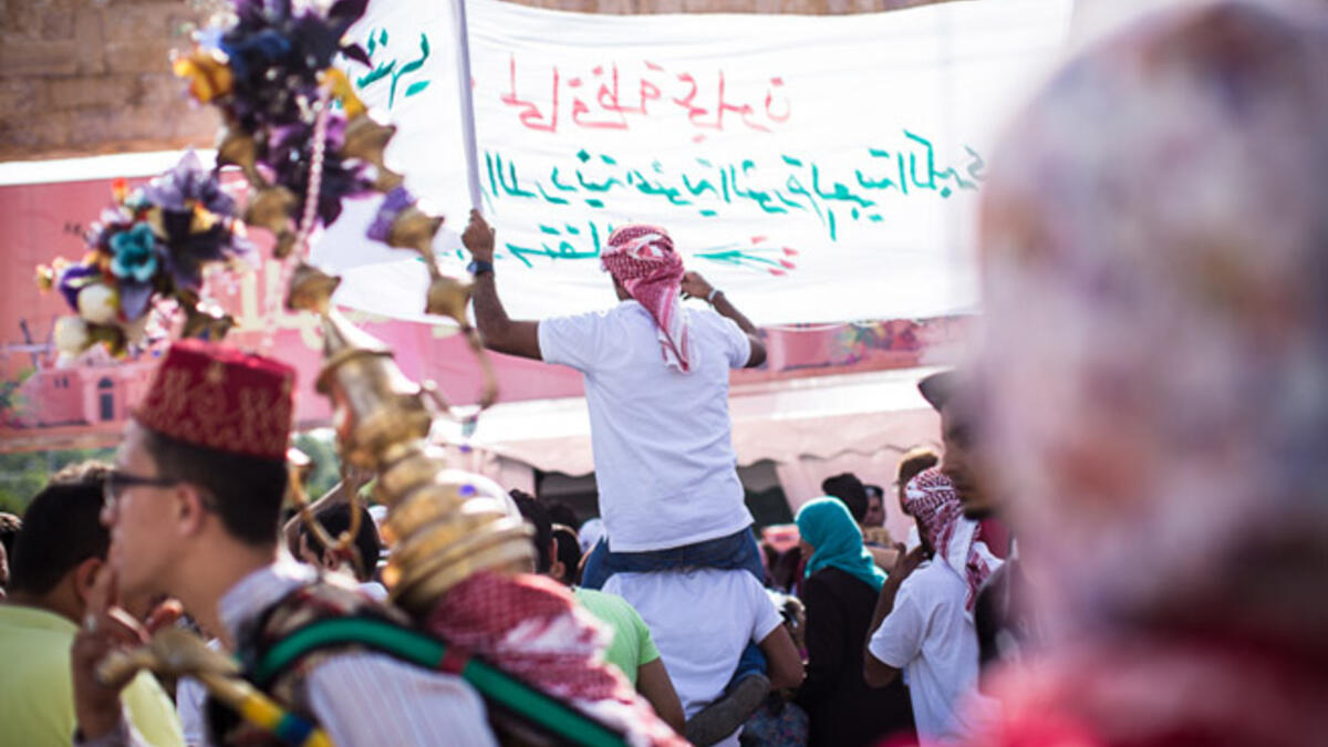 A parade chanting slogans in support of King Abdullah II passes through the crowd outside King Hussein Park in Amman, Jordan, as people gathered to celebrate the 100th anniversary of the Great Arab Revolt on June 3, 2016.