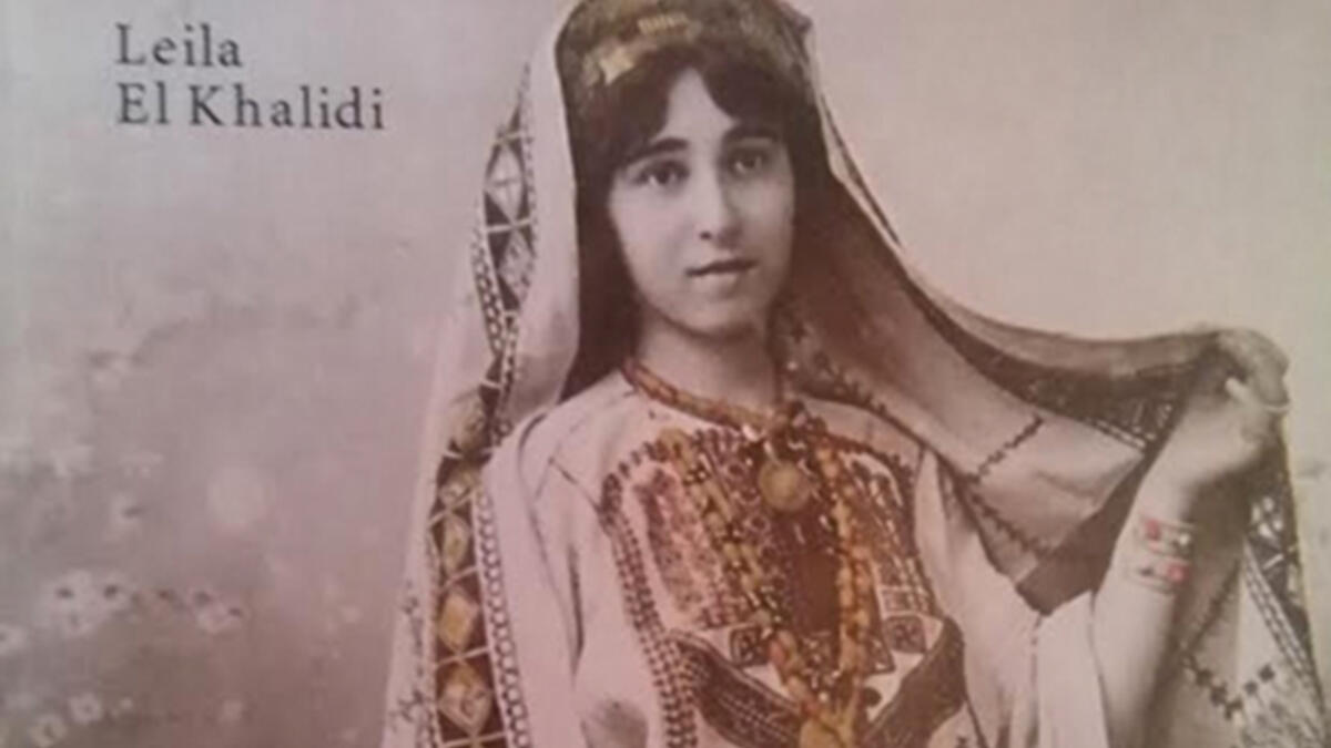 A Palestinian girl wears a traditional embroidered gown and headdress on the book cover of “Art Of Palestinian Embroidery“ by Laila El-Khalidi. (Laila El-Khalid, Saqi Books)