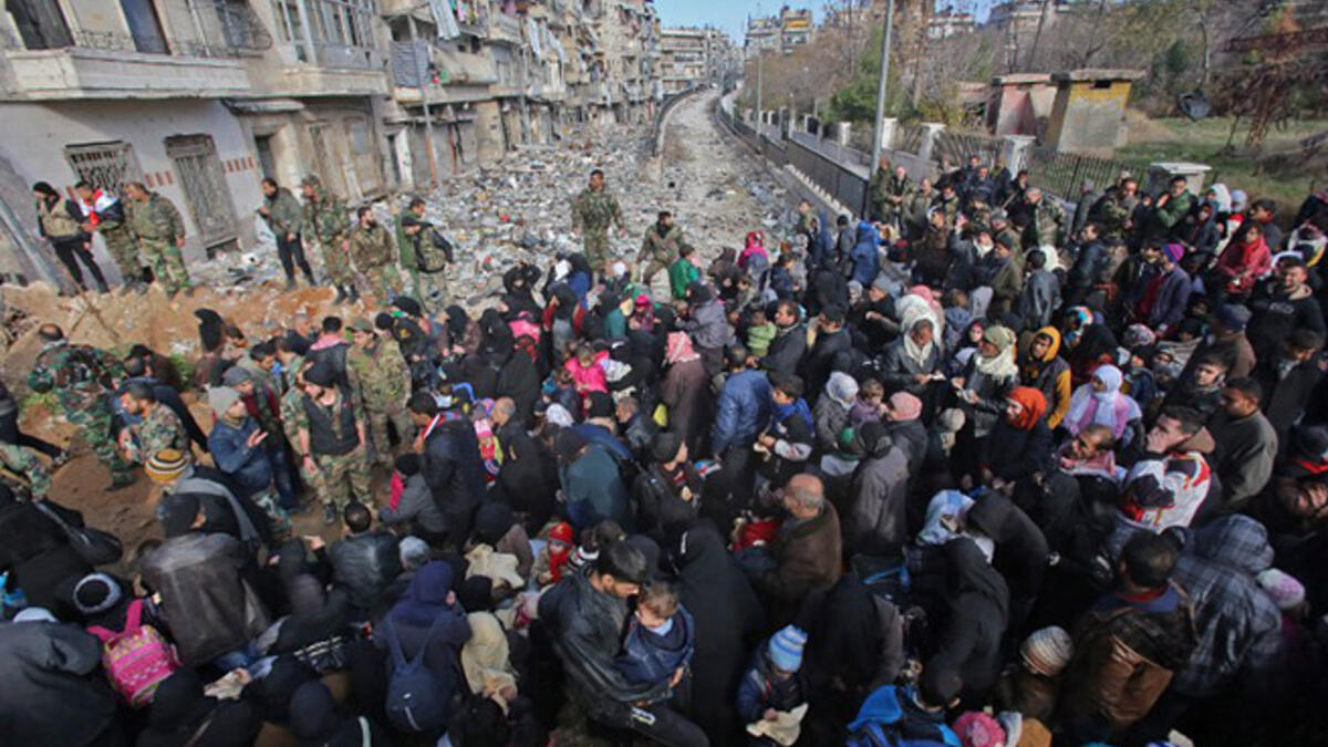 Aleppo’s exodus: Syrian residents fleeing violence gather at a checkpoint, manned by pro-government forces, in the Maysaloun neighborhood of Aleppo on December 8, 2016.